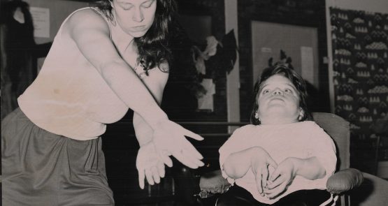 Black-and-white photo of Vicki Balaam dancing next to a wheelchair dancer.