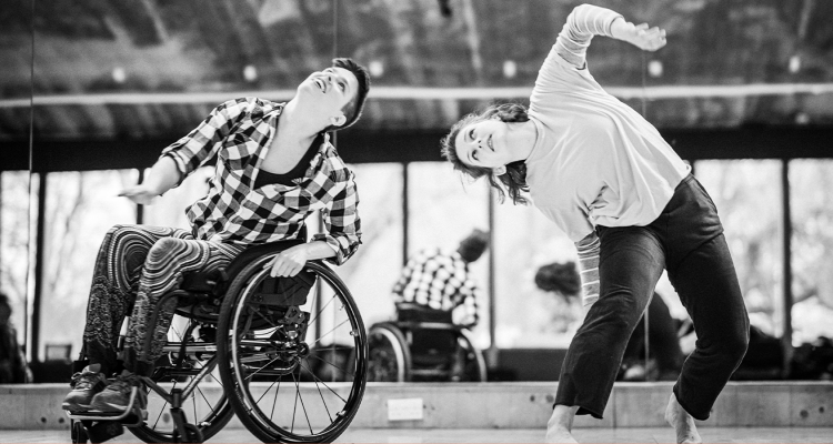 Black-and-white photo of SG2 dancers Kat and Abi moving together in the studio.