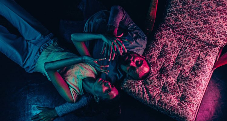 A photo from above of Dave and Meri laying on the floor together.