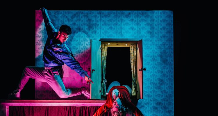 Photo from The Enormous Room - Christian reaches towards Hannah as she leans out from an open cupboard.