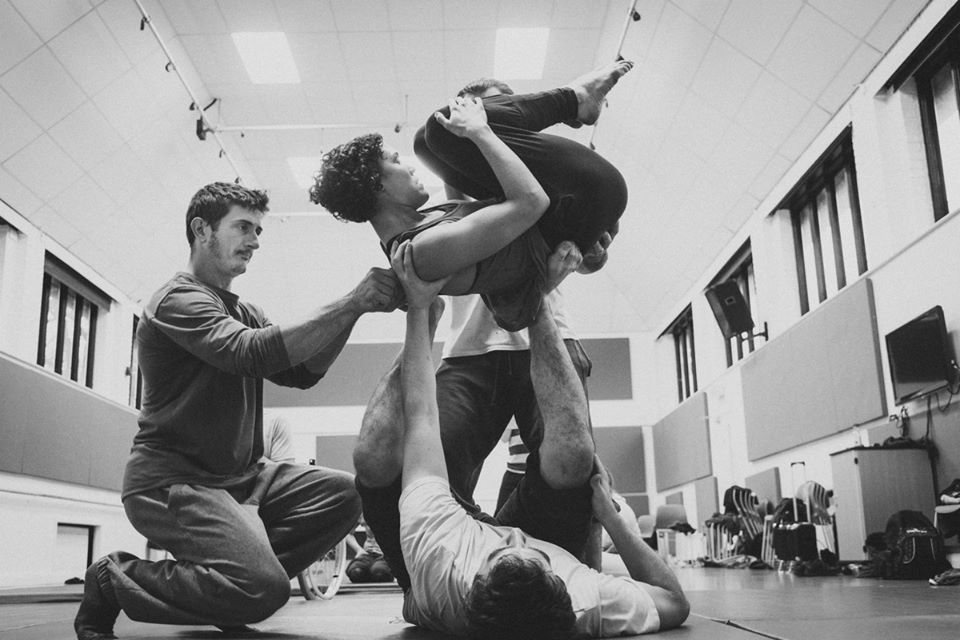 Black and white photo of three dancers practicing balancing