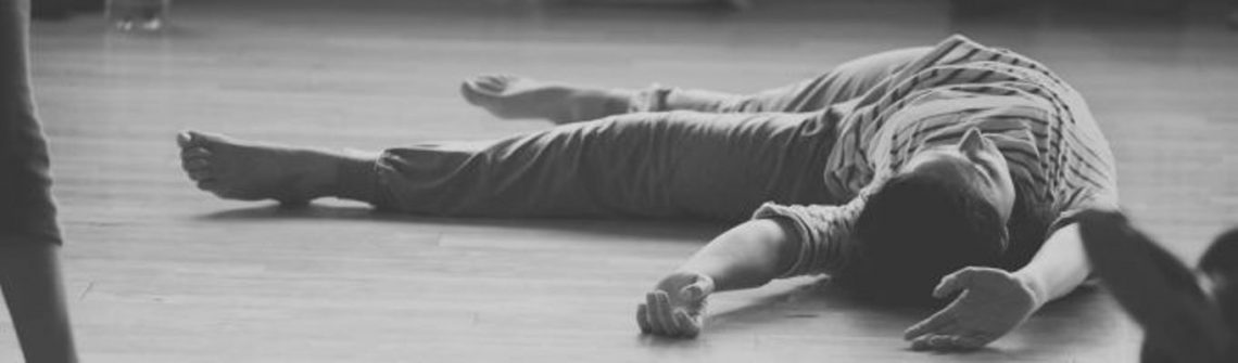 Black and white photo of dancer lying on the floor.