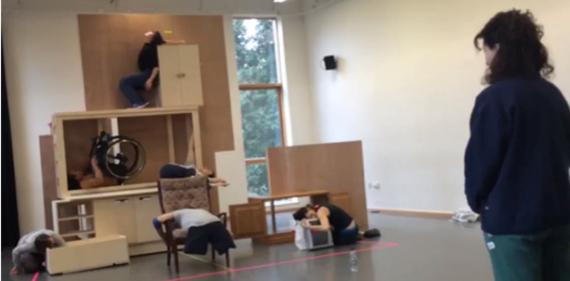 Lucy, with her back to the camera, looking at a set model of The Enormous Room.