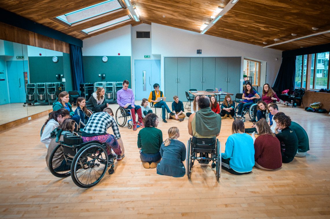 A group of people from Stopgap sat in a circle in a studio.