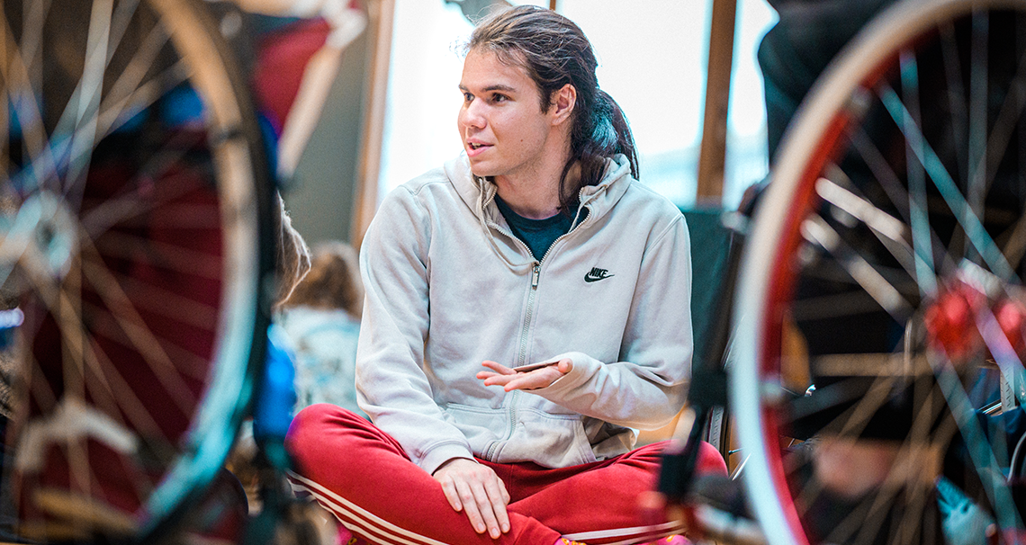 Fin seated on the floor, in conversation.