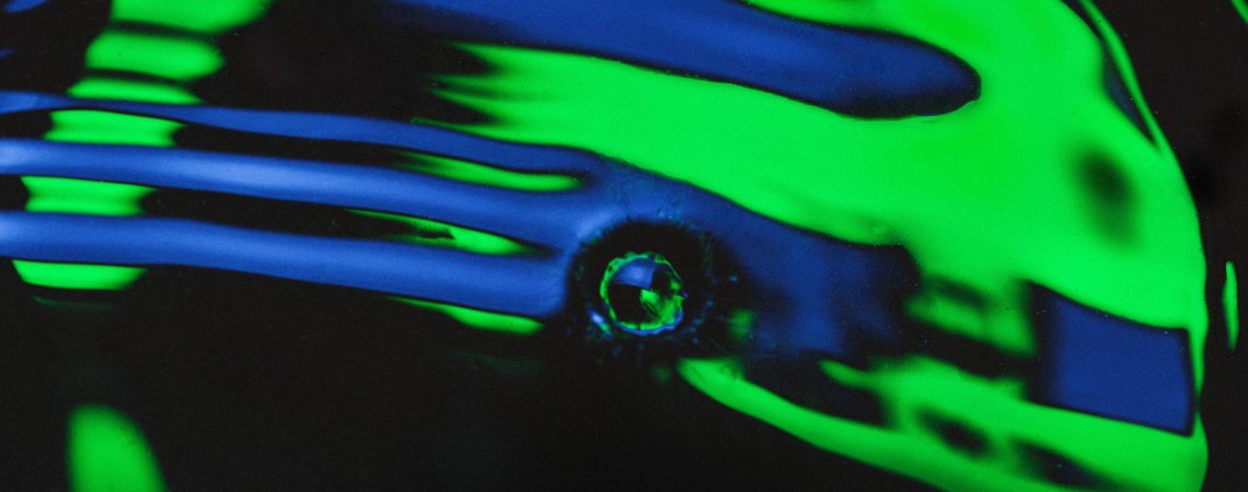 An abstract image of a water droplet lit by neon green and blue light