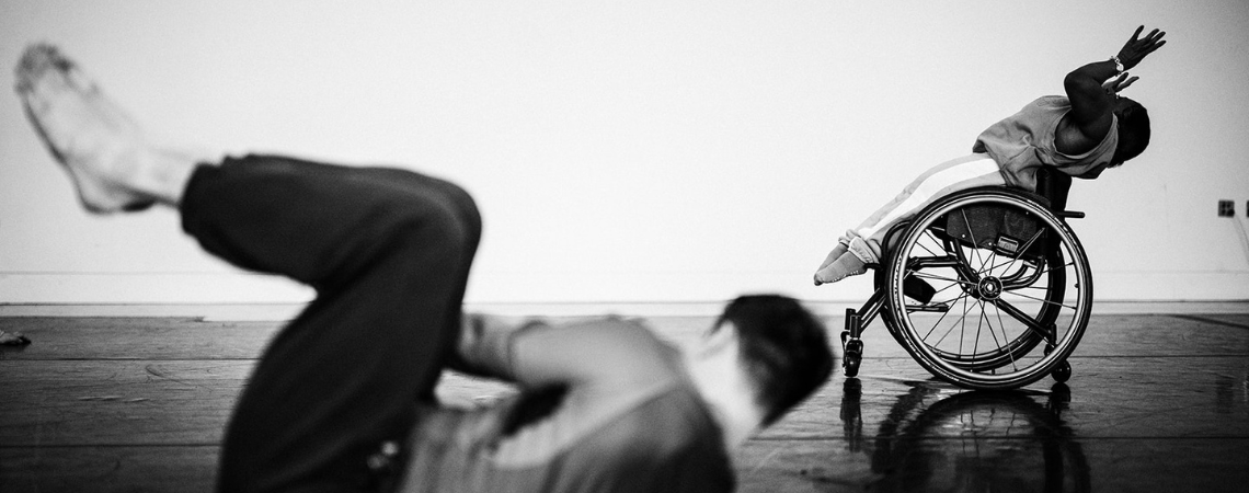 Black and white photo of a wheelchair dancer in the studio.