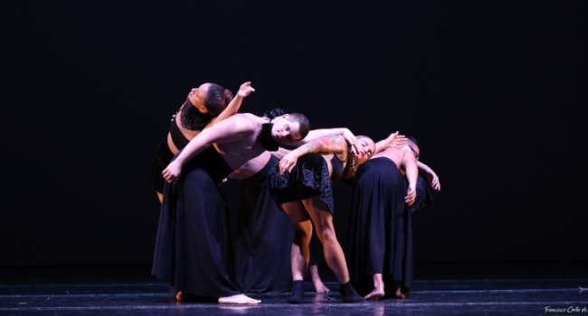 A group of dancers clustered and leaning on each other