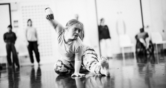 A black and white photo of a dancer with Down syndrome in a studio.