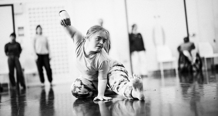 A black and white photo of a dancer with Down syndrome in a studio.
