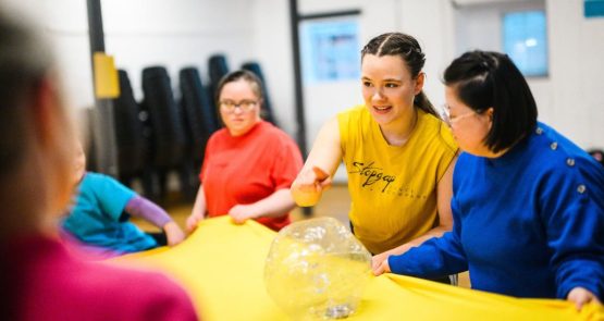 Dancers in bright studio with yellow fabric