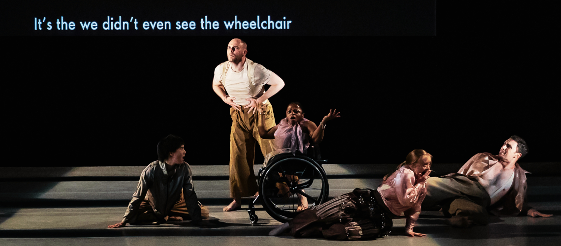 Five dancers on stage, a central wheelchair dancer looks shocked as a caption reads "We didn't even see the wheelchair".