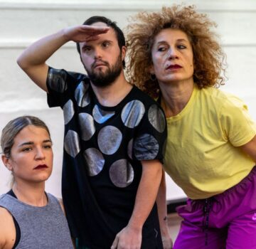 3 Disabled and non-disabled dancers stand and kneel looking into the distance